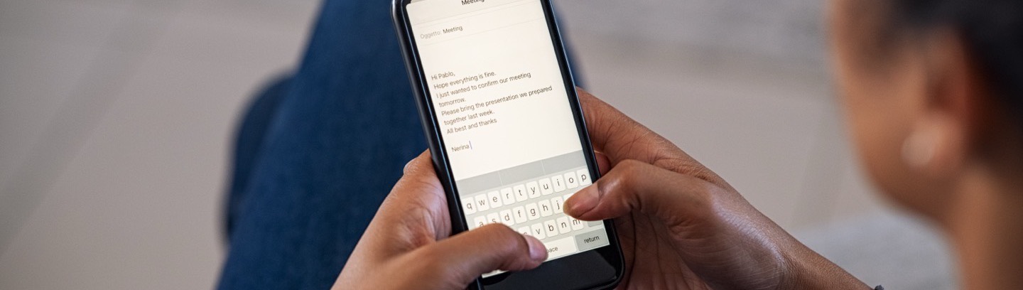 Someone reading a short email on a phone, seen over their shoulder.